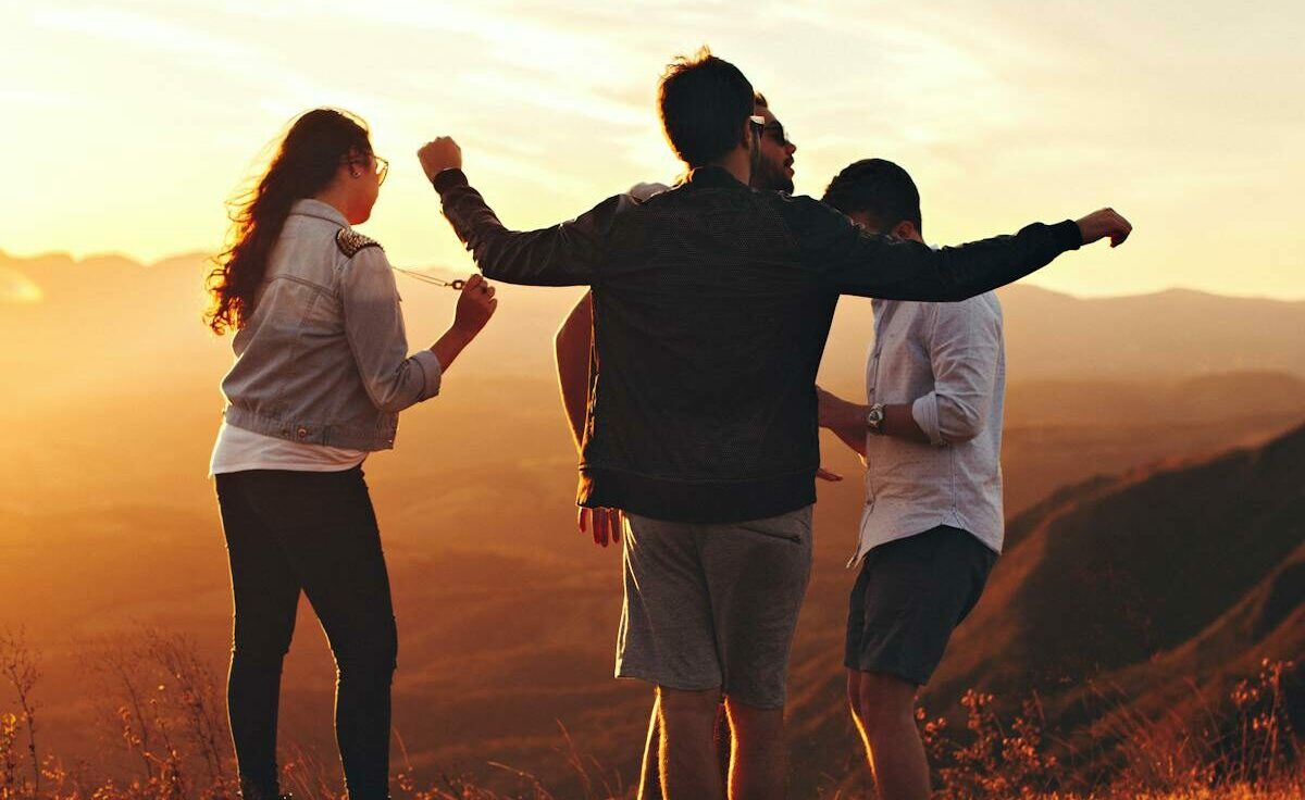 Joyful group of young adults enjoying a sunset view in a mountainous landscape in Brazil.